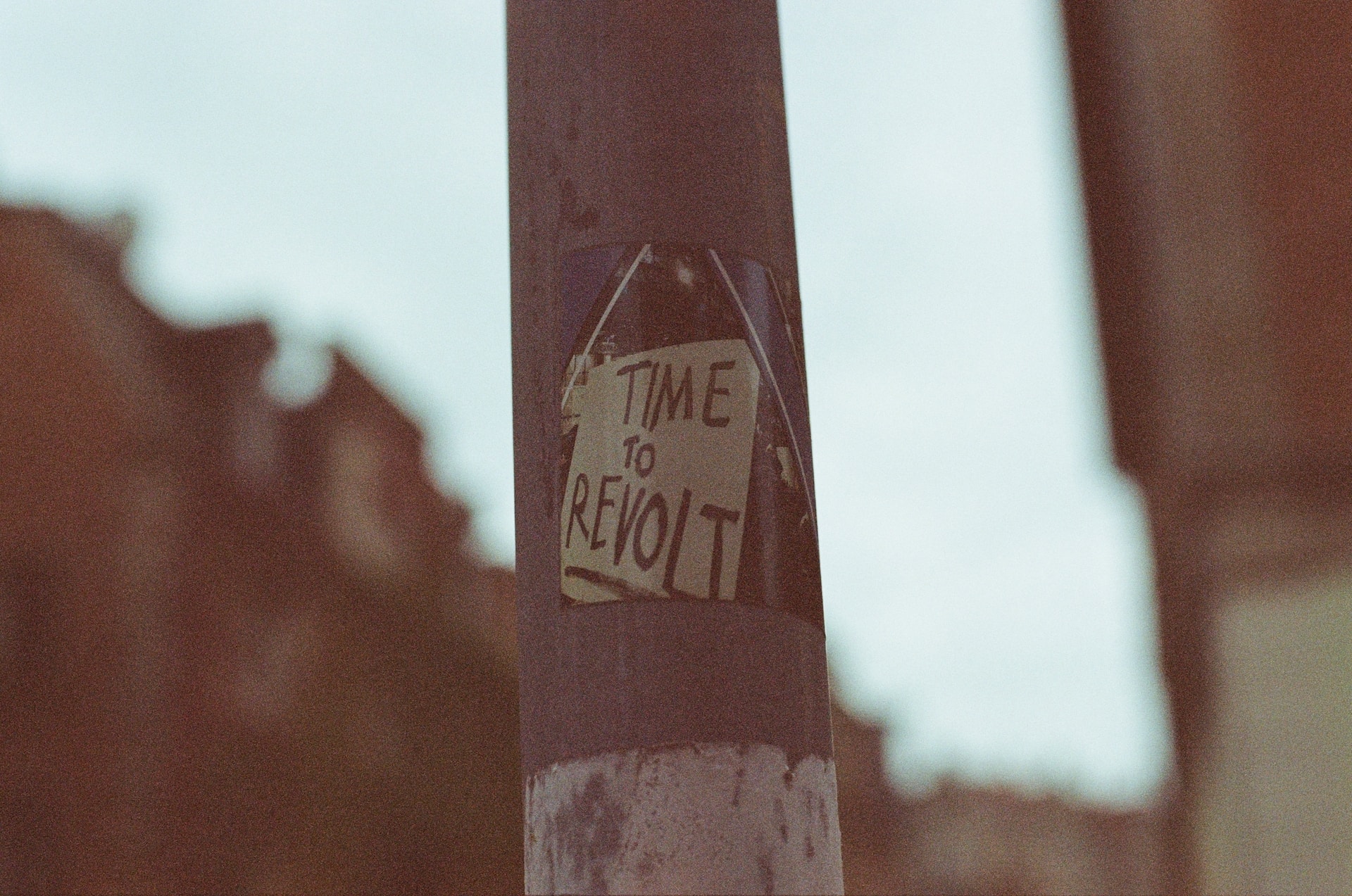 Auf einer Straßenlaterne klebt die Aufschrift "Time to revolt"